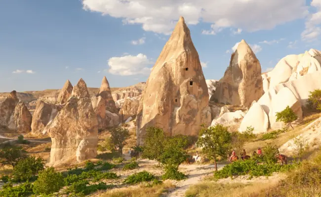Fairy chimneys of Cappadocia's Rose Valley at golden hour with riders on the trail — day three and four of the 8 day Turkey itinerary