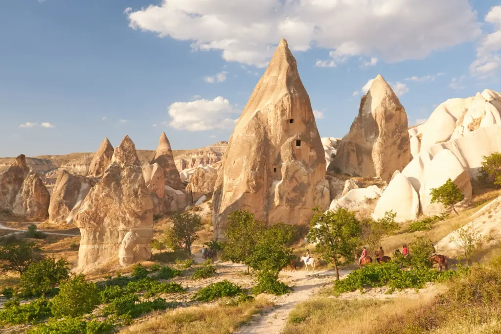 Riders on horseback below the fairy chimneys of the Cappadocia valleys