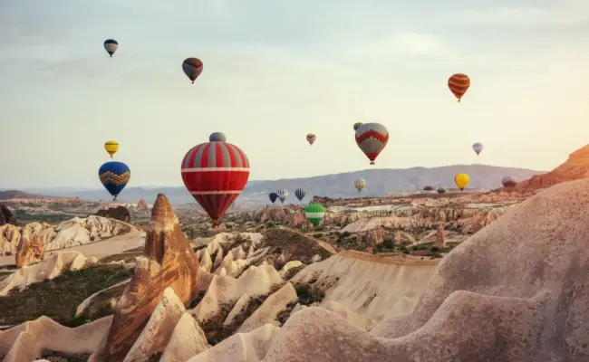 Hot air balloon flying over rock landscape at cappadocia turkey