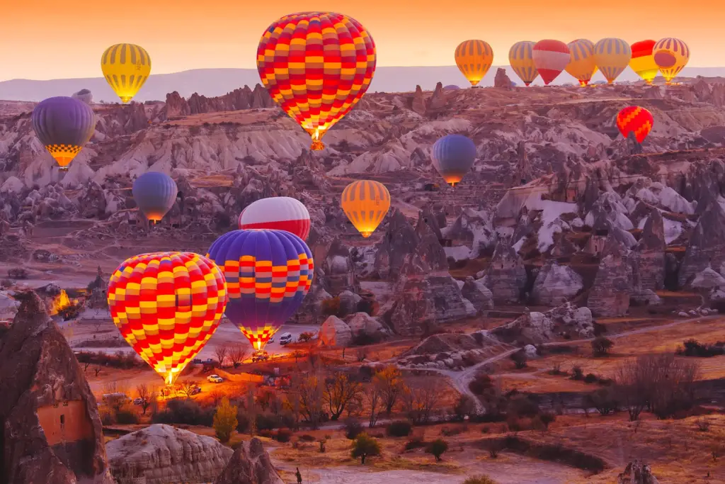 Colourful hot air balloons rising at sunrise over the rock valleys of Cappadocia